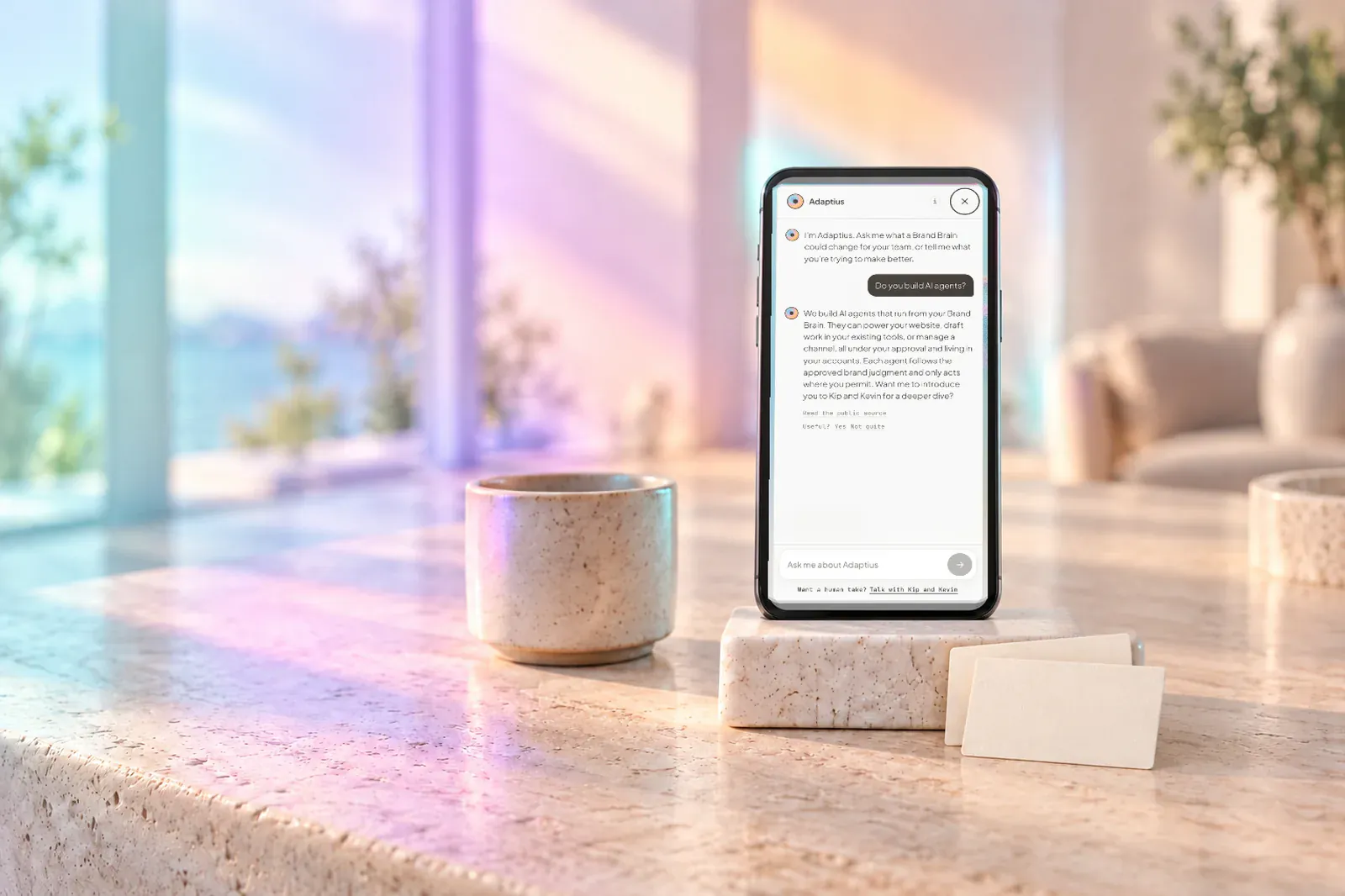 A phone on a stone counter showing a site assistant conversation, in soft plasma window light